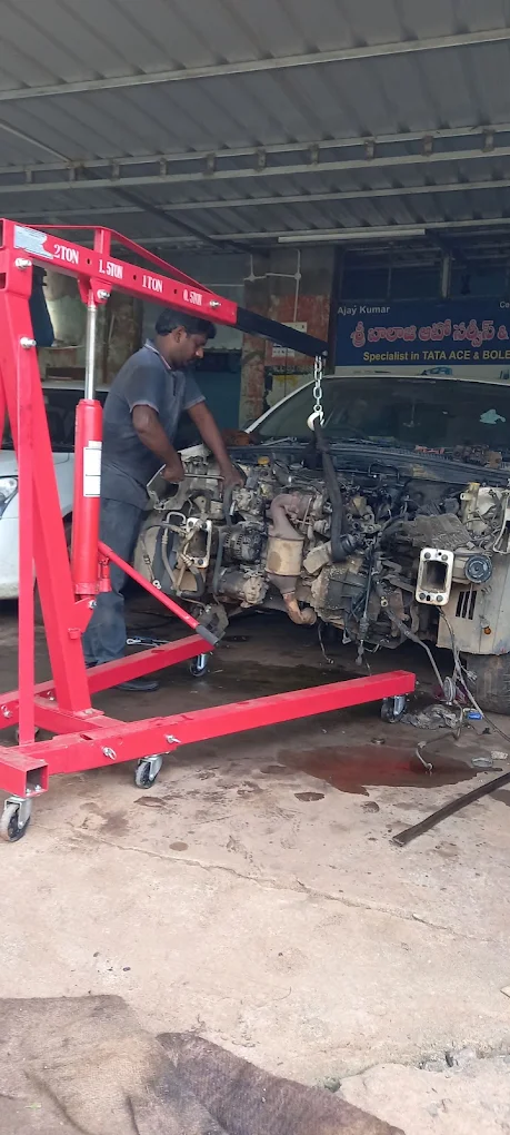 Technician lifting an engine out with a hydraulic crane